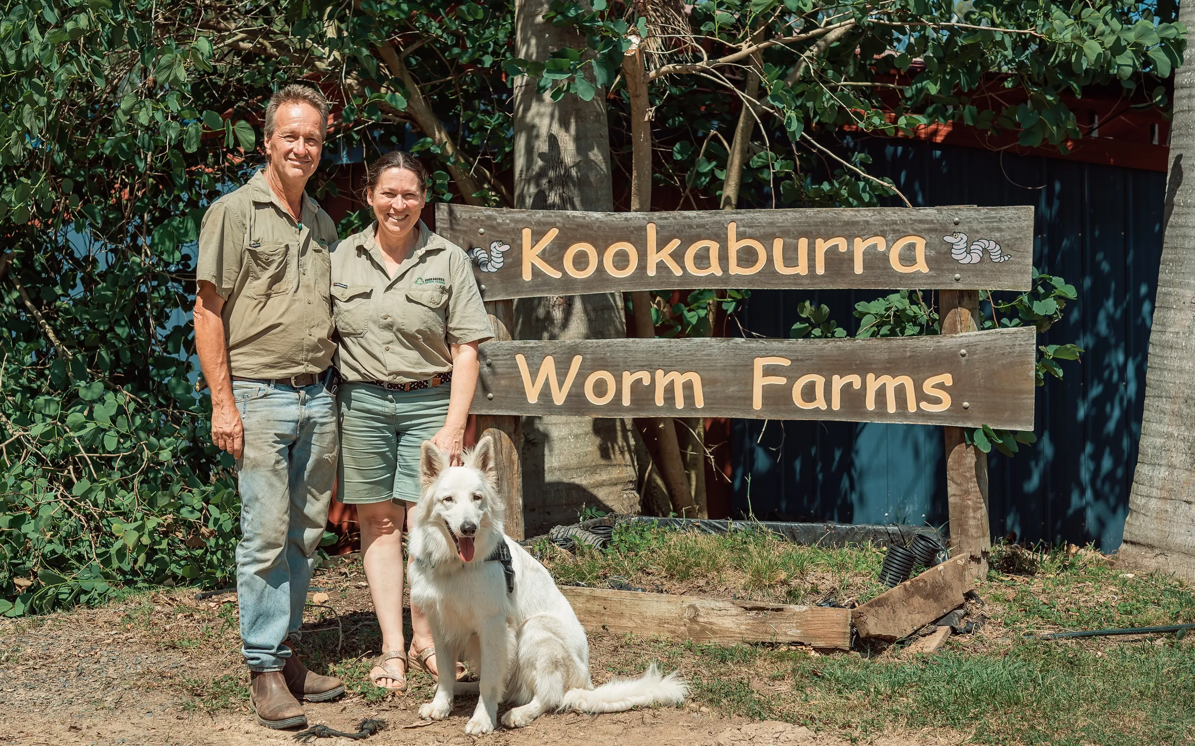 George, Kath and Bear the farm dog at the Kookaburra Worm Farms sign in Gin Gin